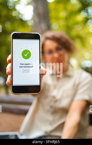 Person holding smartphone displaying successful digital payment transaction Stock Photo