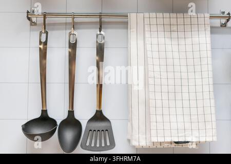 kitchen utensils hanging on the wall and towel Stock Photo