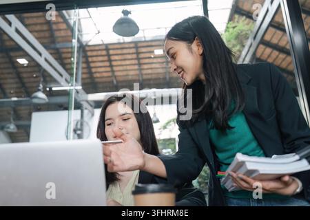 A diverse group of female professionals engages in discussions about strategies and analyzes project data, showcasing collaboration in a vibrant works Stock Photo