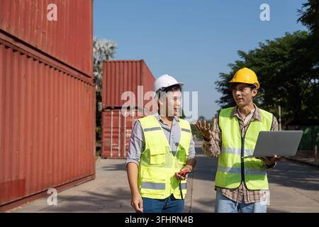 Two engineers engage in a strategic discussion about logistics while using a laptop, emphasizing modern planning techniques. Stock Photo