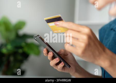 Digital Payments and Financial Planning. A young woman confidently using her credit card and smartphone to track spending. Stock Photo