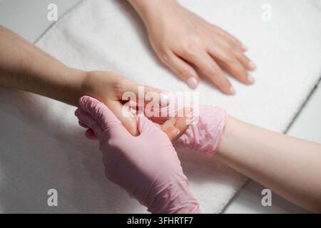 Close-up hands beautician, woman's hands receive manicure treatment, master Stock Photo