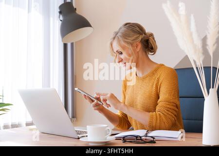 Attractive european business woman is on phone and taking notes at same time Stock Photo