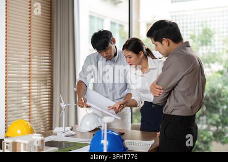 A team collaborates on architectural project planning, emphasizing sustainable practices and innovative designs in the workspace. Stock Photo
