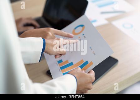 Colleagues engaging in a data analysis session, focusing on financial growth and strategic planning in a modern workspace. Stock Photo