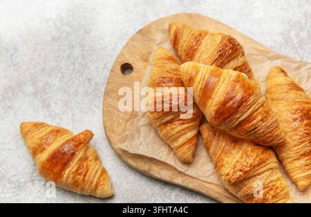 Freshly baked croissants on wooden board Stock Photo