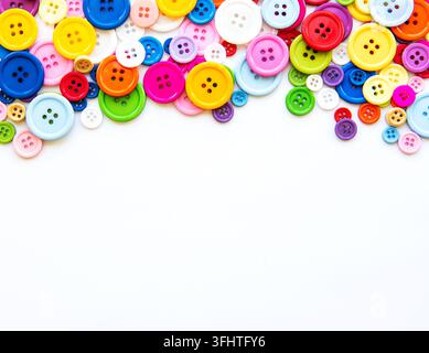 Multicolored sewing buttons on a white background. Sewing border, top view Stock Photo