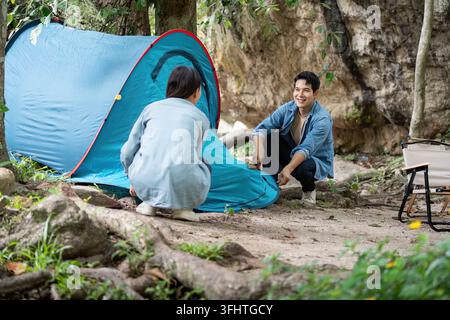 Couple Setting Up Tent While Camping in the Forest Stock Photo