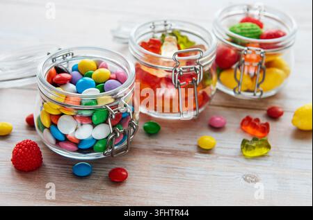 Colorful candies, jelly and marmalade in jars on the table Stock Photo