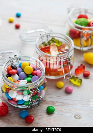 Colorful candies in jars on table Stock Photo
