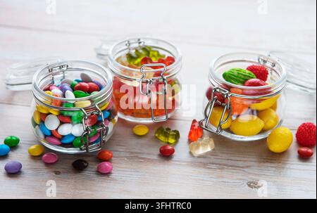 Colorful candies, jelly and marmalade in jars on the table Stock Photo