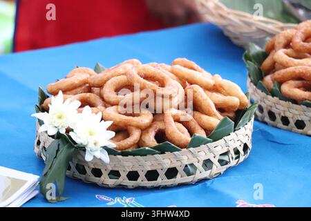 Traditional Indonesian Sweet Ring Cakes (Kue Cincin) in Woven Baskets Decorated with White Flowers Stock Photo