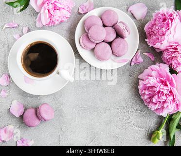 Pink peony with coffee and macarons on a concrete background Stock Photo