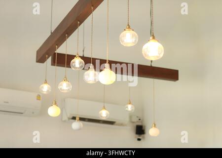 Aesthetic wooden beam ceiling with multiple hanging Edison pendant lights Stock Photo