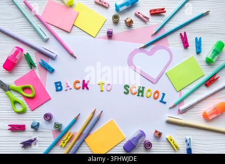 Frame of different stationery on white wooden background, flat lay with space for text. Back to school Stock Photo