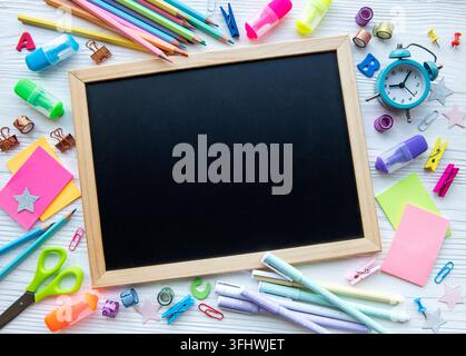 Frame of different stationery on white wooden background, flat lay with space for text. Back to school Stock Photo