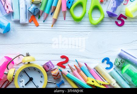 Frame of different stationery on white wooden background, flat lay with space for text. Back to school Stock Photo
