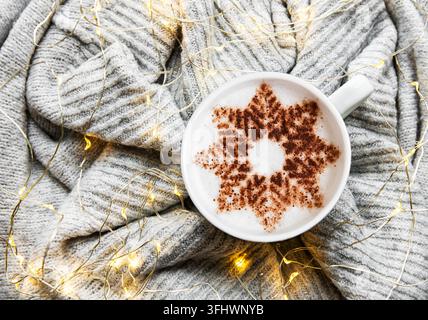 Coffee with a snowflake pattern on a warm knitted sweater Stock Photo