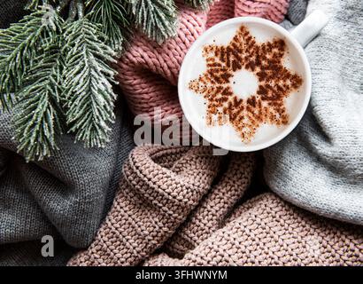 Coffee with a snowflake pattern on a warm knitted sweaters Stock Photo