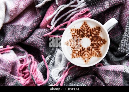 Coffee with a snowflake pattern on a warm woolen plaid Stock Photo
