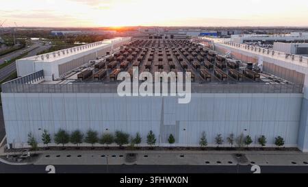 Aerial drone view of modern data center facility in Ashburn, Virginia at sunset with rows of cooling units on rooftop, symbolizing cloud computing, AI Stock Photo