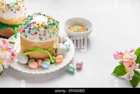 Easter cakes decorated with colorful sprinkles and chocolate eggs on festive table Stock Photo