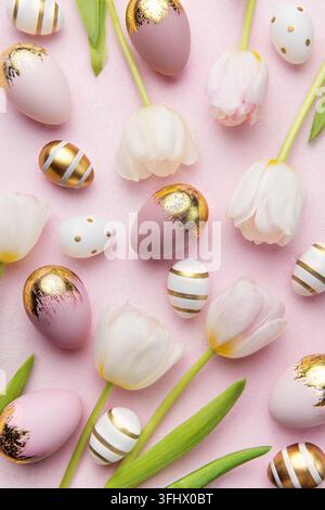 Easter golden eggs and pink tulips on pink  background. Stock Photo