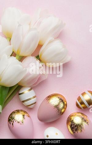 Easter golden eggs and pink tulips on pink  background. Stock Photo