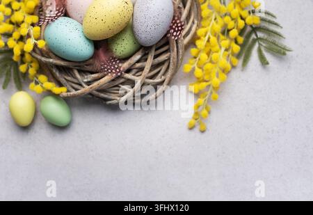 Colorful Easter Eggs Nestled in a Wicker Basket With Yellow Flowers on a Light Background Stock Photo
