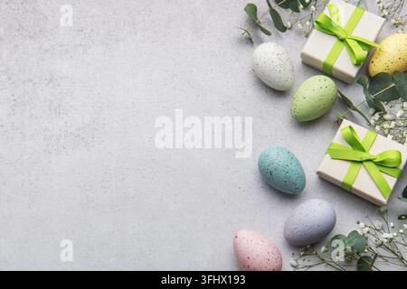 Colorful easter eggs and gift boxes with greenery Stock Photo