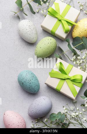 Colorful easter eggs and gift boxes with greenery Stock Photo