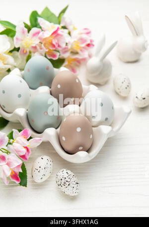 Easter eggs with spring flowers and ceramic bunnies celebrating easter sunday Stock Photo
