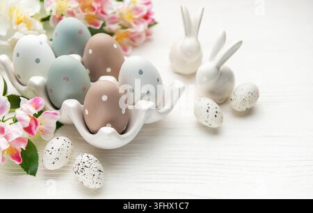 Easter eggs with spring flowers and ceramic bunnies celebrating easter sunday Stock Photo