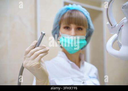 A female dentist holds a boron machine in her hand Stock Photo