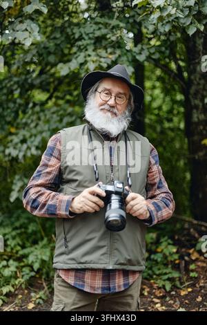 Portrait of Senior Man Holding Digital Camera in Forest Stock Photo