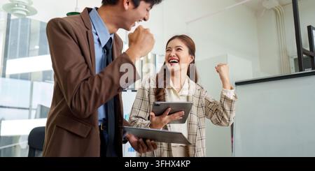 Celebration of Success. Colleagues sharing joyful moment after achieving business goals. Stock Photo
