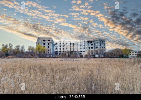 Abandoned unfinished building in reed beds at sunset Stock Photo