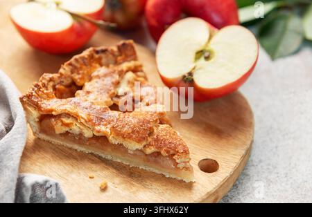 Apple pie slice on wooden board with apples Stock Photo