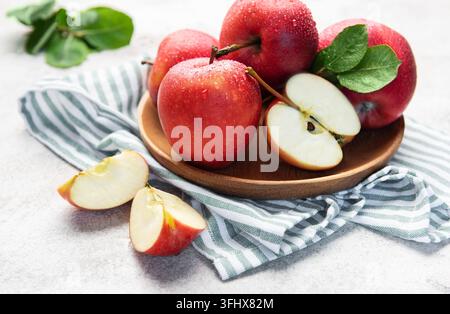 Fresh red apples in wooden bowl with slices Stock Photo