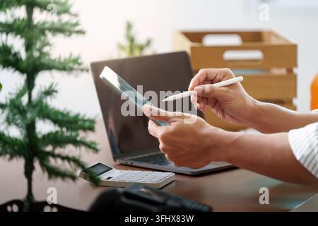 An individual engages with a tablet and stylus, blending technology and creativity in a contemporary workspace. Stock Photo