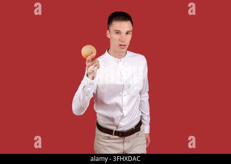 Young handsome man wearing white shirt standing over isolated red background Stock Photo