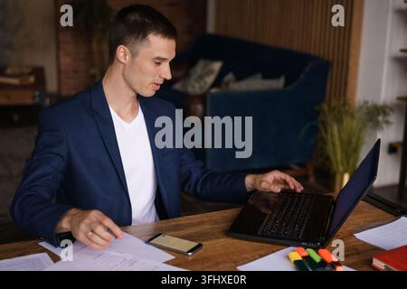 Portrait banking finance analyst in jacket working in home office on laptop Stock Photo