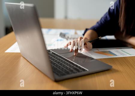 Close up woman using calculator and laptop, reading documents, young female checking finances, counting bills or taxes, online banking services. Stock Photo