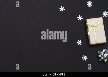 Gift boxes and snowflakes on dark paper black background. Christmas gift. Stock Photo