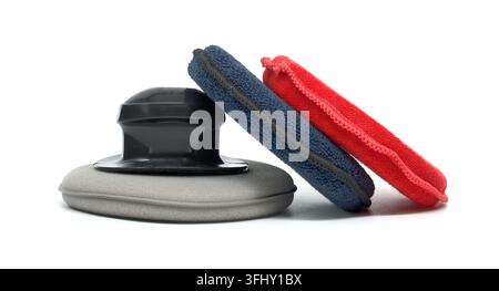 A set of automotive detailing tools including a foam applicator pad and two microfiber cloths for wax and polish application Stock Photo
