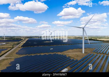 Many white wind turbines stand on dry hillside under bright clear blue ...