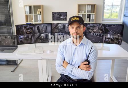 Security Guard Monitoring CCTV Cameras in Modern Professional Control Room Stock Photo