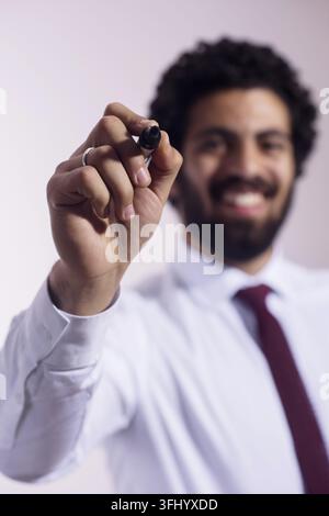 Businessman writing with marker while smiling during presentation or brainstorming session in office Stock Photo