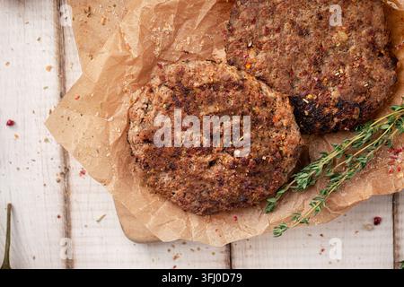 Two fried burger patties on wooden board Stock Photo