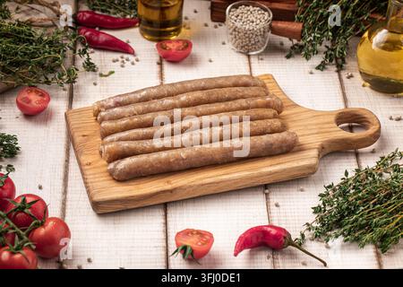 Raw chicken sausages on cutting board Stock Photo